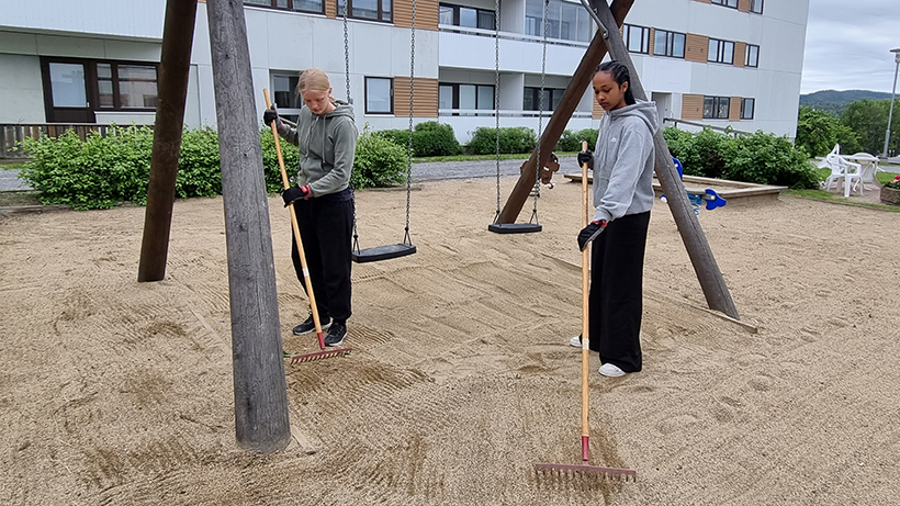 Hadia Tinawi och Hilma Jonsson krattar sanden i en av lekparkerna. 