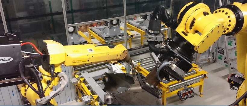 De två industrirobotarna arbetar synkroniserat för att svetsningen ska bli så effektiv som möjligt.