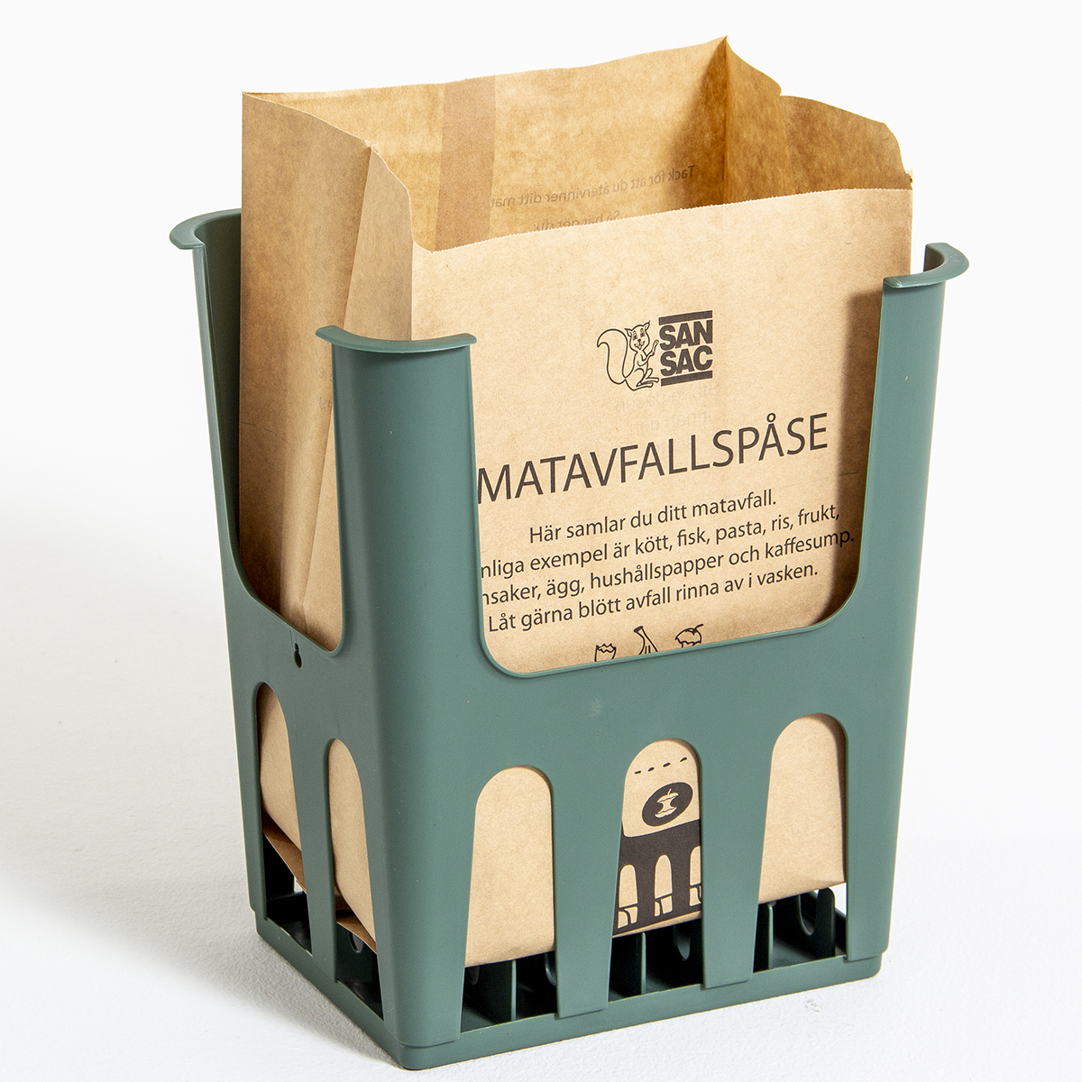 Grön plasthållare med en brun papperspåse som används för matavfallsinsamling